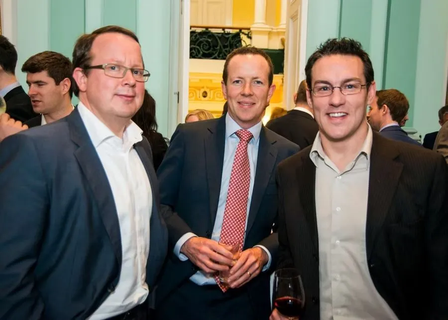 Three business leaders smiling at an event